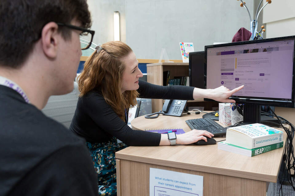 Woman pointing at information on a computer screen