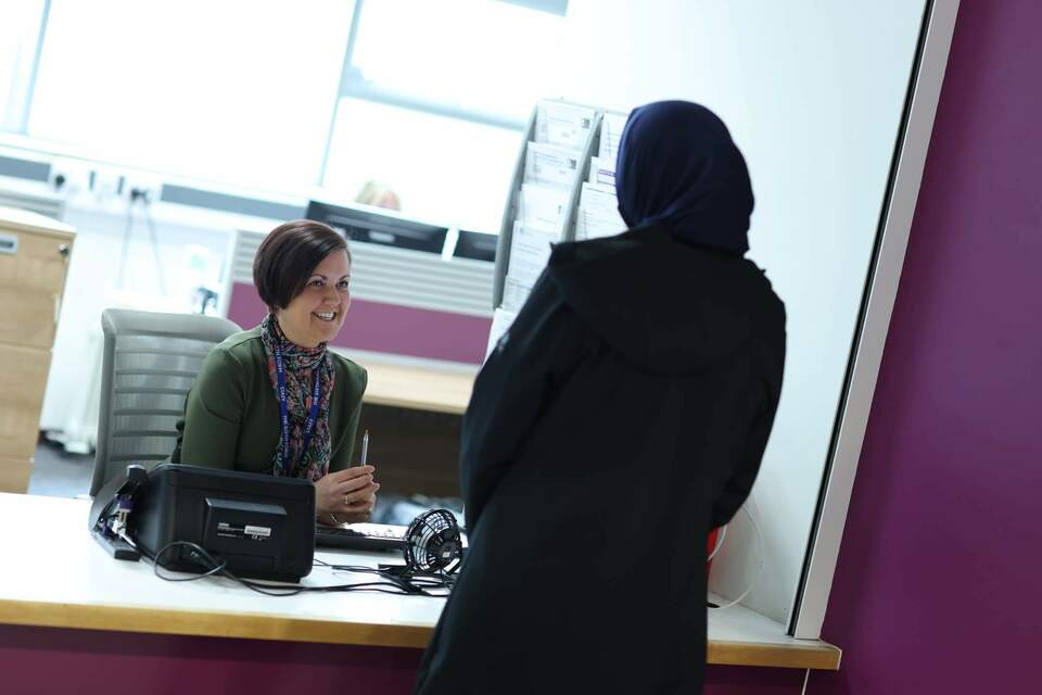 Staff behind a reception desk offering advice