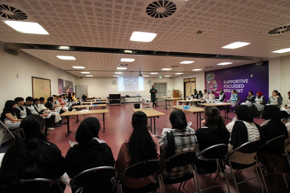 Students watching presenter perform dissection